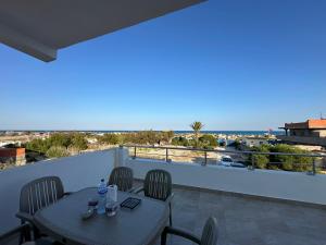 a table and chairs on a balcony with a view of the ocean at Villa Pieds dans l eau entre Lagune et Montagne in Ghār al Milḩ