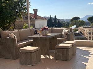a patio with wicker furniture and a table and chairs at Villa Falkoni II in Dubrovnik