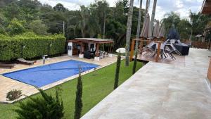 a backyard with a swimming pool and an umbrella at Do Sítio Tinoca in Atibaia