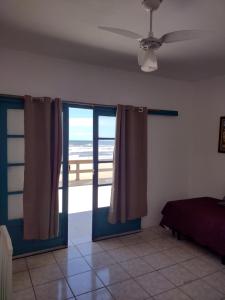a bedroom with a door with a view of the ocean at hotel castelo in Cidreira
