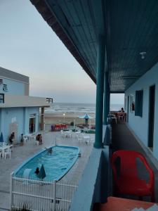 a view of a swimming pool with the ocean in the background at hotel castelo in Cidreira