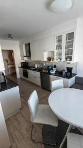 a kitchen with white chairs and a white table at SEA - 3 Bedrooms in Kristinestad