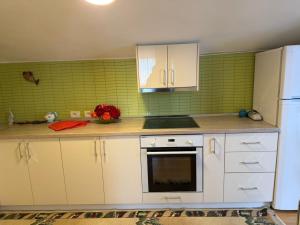 a kitchen with white cabinets and a white refrigerator at Le Toit du Ciel in Pukë