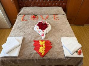 a bed with flowers and a sign that says love at Le Toit du Ciel in Pukë
