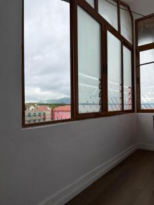 an empty room with windows with a view of a city at Le Toit du Ciel in Pukë