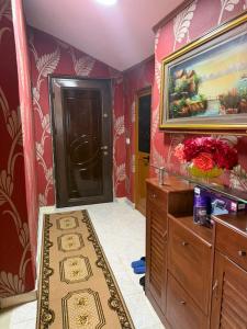 a bathroom with red walls and a painting on the wall at Le Toit du Ciel in Pukë