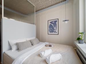 a bedroom with a large white bed with two pillows at Marszałkowska Luxury Apartments by Sofija in Warsaw