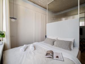 a bedroom with a white bed with towels on it at Marszałkowska Luxury Apartments by Sofija in Warsaw