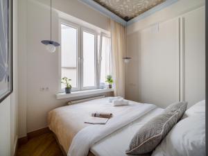 a bedroom with a large white bed with a window at Marszałkowska Luxury Apartments by Sofija in Warsaw