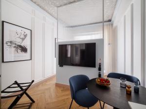 a living room with a table and chairs and a tv at Marszałkowska Luxury Apartments by Sofija in Warsaw
