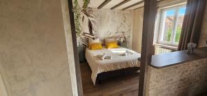 a bedroom with a bed with yellow pillows and a window at Chez Denise in Eglingen