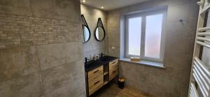 a bathroom with a sink and two mirrors on the wall at Chez Denise in Eglingen +12 photos