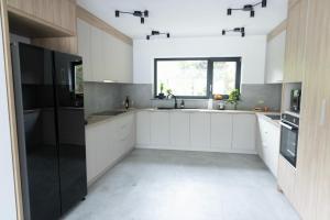 a kitchen with white cabinets and a sink and a window at Mira Montis in Borşa