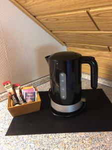a black coffee pot sitting on a counter next to a box at Gemütliches Studio am Riepen in Hameln