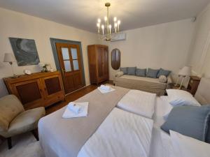 a large bedroom with two beds and a couch at Annushka Apartman in Sarud