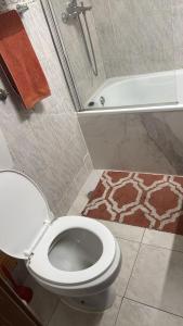 a bathroom with a toilet and a shower and a tub at Siroco Nau Algarve in Olhão