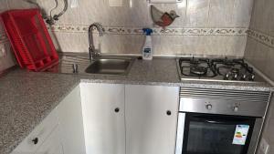 a kitchen counter with a sink and a stove at Siroco Nau Algarve in Olhão
