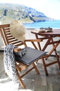 a straw hat sitting on a chair next to a table at Blue horizon apartment & suite in Kalymnos