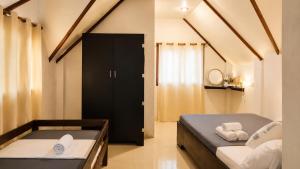 a bedroom with a bed and a black door at Wave Cafe INN in General Luna