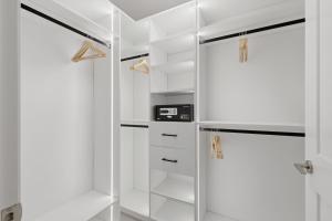 a white walk in closet with a glass door at Widmr Residences in Toronto