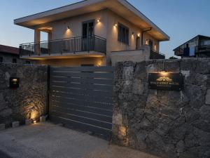 a house with a fence and a stone wall at Reale Guest House in Mascalucia +22 photos