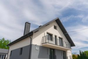 a white building with a balcony on top of it at Słoneczna 49 in Miedziana Góra