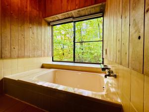 a bath tub in a bathroom with a window at コテージちゃ豆ん家 in Nasu +48 photos
