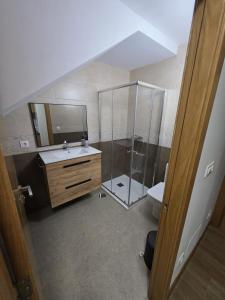 a bathroom with a shower and a sink and a mirror at Alojamientos ADRIMAR in Arnuero +25 photos