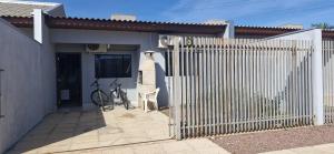 a fence in front of a house with a bicycle at Casa 2 quartos, Pet Friendly, 06 pessoas Sinop in Sinop