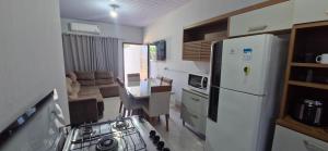 a kitchen with a white refrigerator and a table and a couch at Casa 2 quartos, Pet Friendly, 06 pessoas Sinop in Sinop