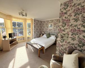 a bedroom with a bed and floral wallpaper at Ingleside in Lynton