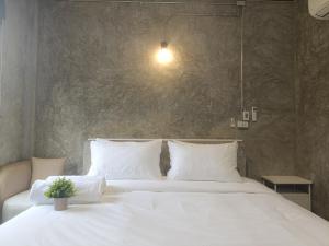 a bedroom with a white bed with a potted plant on it at View Doi Resort in Ban Mai Thung Mot