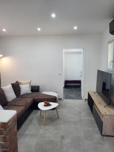 a living room with a couch and a table at Appart Allée des chênes in Furiani