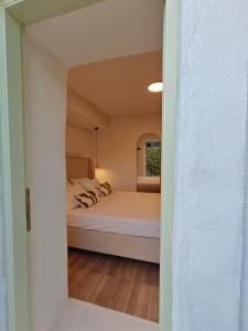 a room with a bed and a window at Maison Jolie in Vlachopoulátika