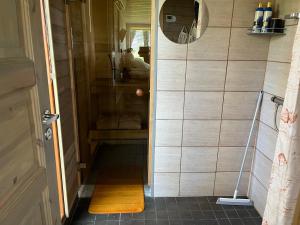 a walk in shower in a bathroom with a mirror at sun& relax- TINYHOUSE in Sõitme +28 photos