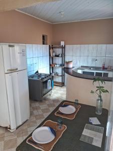 a kitchen with a refrigerator and a counter with plates on it at Casa 89 in Itacaré
