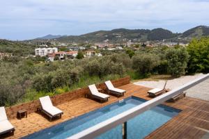 a swimming pool with lounge chairs on the roof of a house at Pnoes Suites Apartments in Skiathos