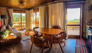 a living room with a wooden table and chairs at Luz de Arcturus, Chalé com jacuzzi aquecida in Imbituba