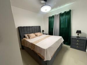 a bedroom with a large bed with green curtains at Apartment With Swimming Pool close to Beach in La Romana +27 photos