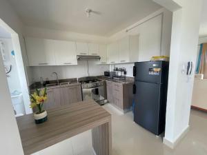a kitchen with a black refrigerator and a wooden table at Apartment With Swimming Pool close to Beach in La Romana