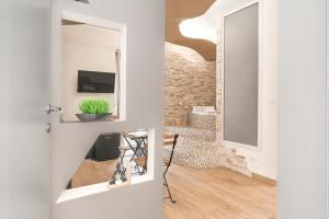 a hallway with a door with a mirror and a plant at Elite Apartment SPA in Catania