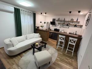 a living room with a white couch and a kitchen at Vila Pogled in Novi Sad