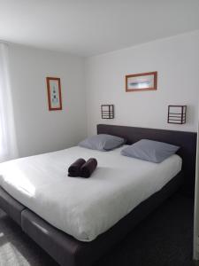 a bed with two brown pillows on top of it at Kyriad Direct Saintes in Saintes