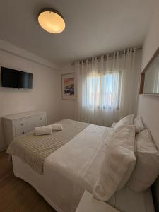 a bedroom with a white bed and a window at RIVER VIEW TMB oporto station house in Porto
