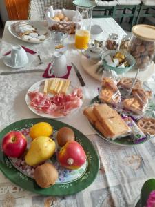 a table with plates of food on a table at Cortile Fiorito Bed and Breakfast mini appartamento in Gorizia +51 photos