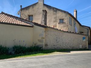 an old white building with two chimneys on it at La Petite Quinotte in Cadillac