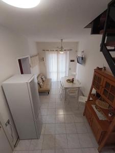 a kitchen with a white refrigerator and a table at Casa Orchidea in Villasimius