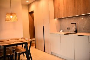 a small kitchen with a table and a sink at Szept Lasu in Żabiczyn +11 photos