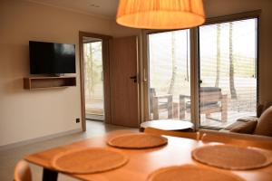 a living room with a table and a large window at Szept Lasu in Żabiczyn
