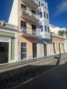 a tall building with balconies on a street at Casa Luna Royale in San Juan